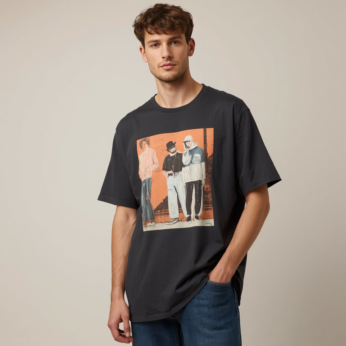 Mann trägt ein dunkles Oversize T-Shirt mit einem quadratischen Grafikprint von drei Personen, Rundhalsausschnitt und kurzen Ärmeln zu blauen Jeans.